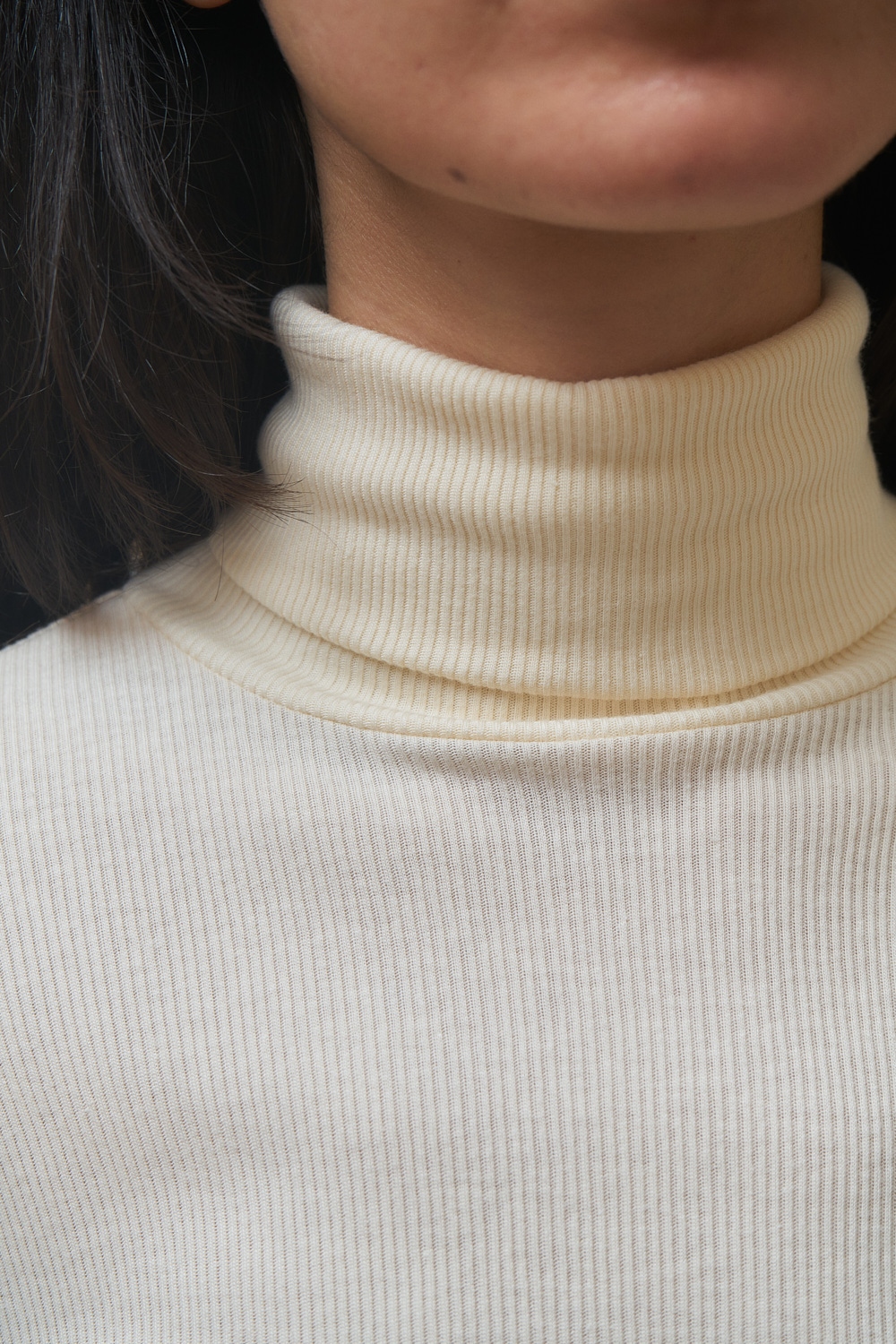 Bea highneck blouse with turtleneck and long sleeves. Cream coloured organic cotton and modal rib. Closeup look of the turtleneck.