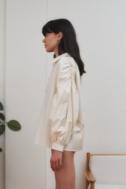 Eba shirt organic cotton shirt with gathered details on the sleeves and body. Ecru unbleached color. Side view of the sleeve.