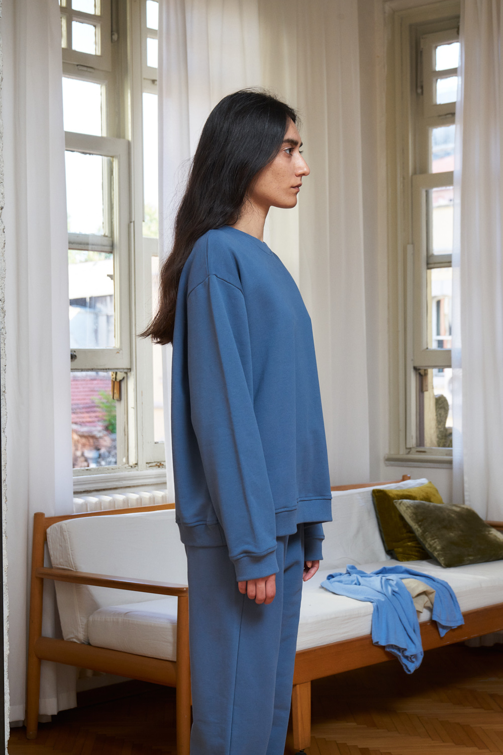 Side view of sea blue coloured organic cotton sweatshirt. Loose fit and rib details on the hemline and sleeves.