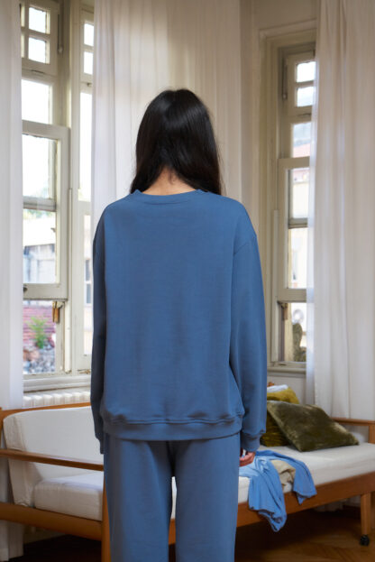 backside of sea blue coloured organic cotton sweatshirt. Loose fit and rib details on the hemline and sleeves.